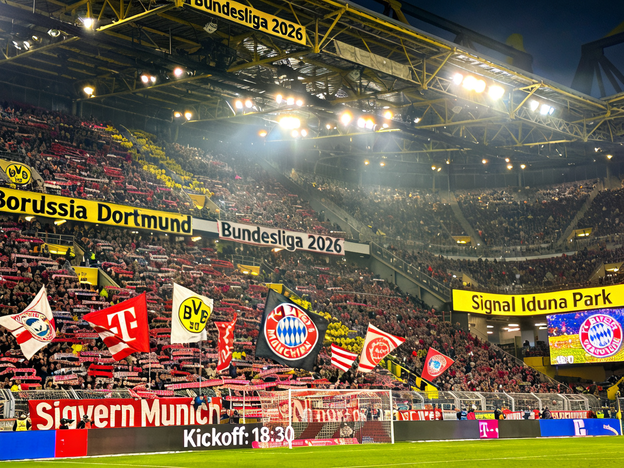 Packed stadium with fans waving flags at a Bundesliga match, Signal Iduna Park atmosphere