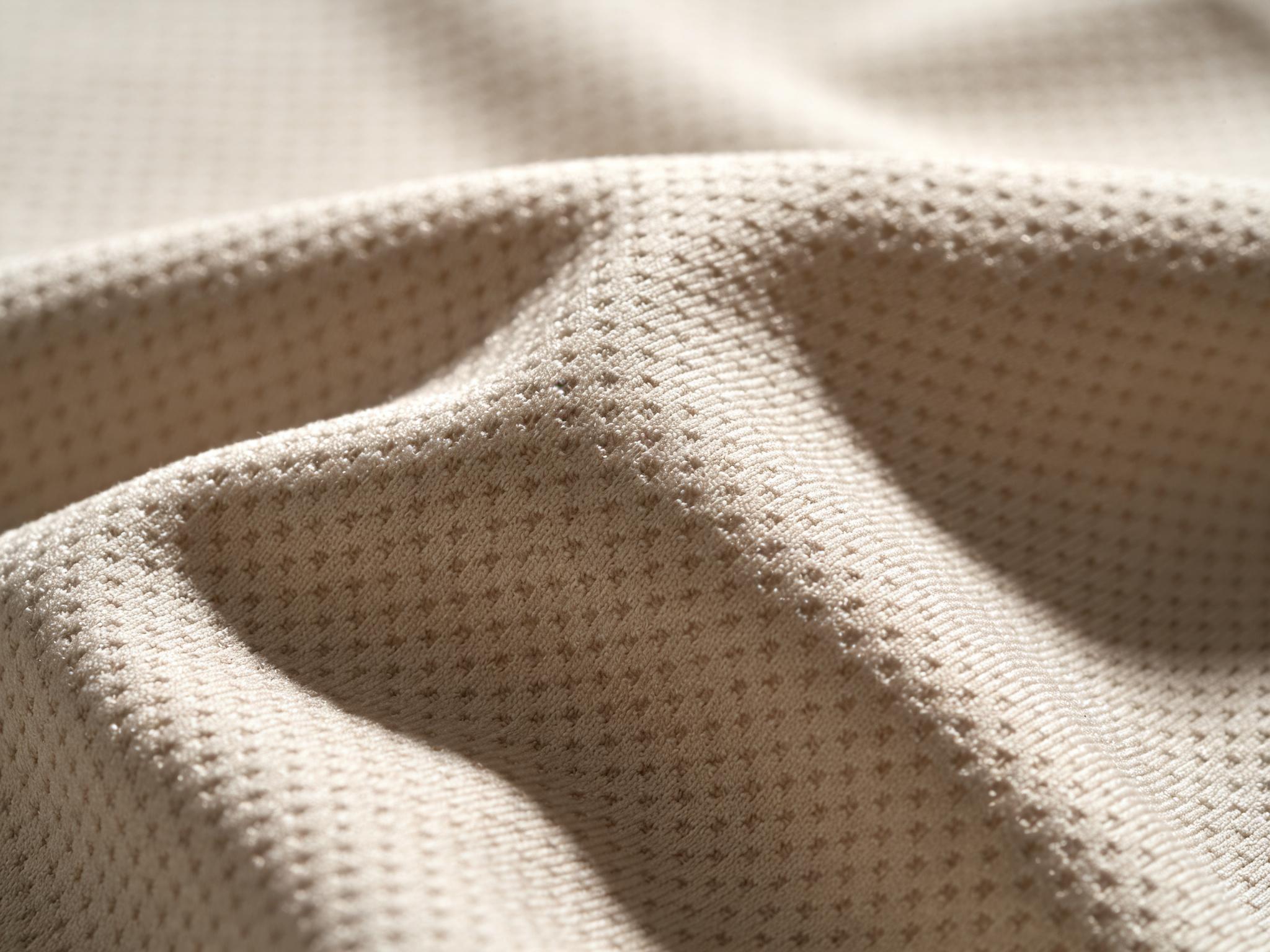 A close-up, detailed photo of a jersey fabric, highlighting the knit texture and moisture-wicking technology.